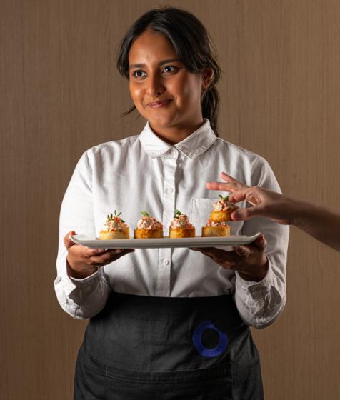 A guest takes a locally made snack from one of our servers